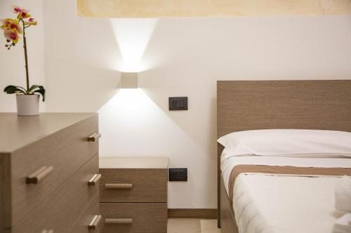 a bedroom with a bed and a dresser with a plant at Piave77 in Bagheria