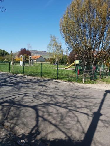 a shadow of a fence on a road with a playground at Appartement chic et cosy in Authézat