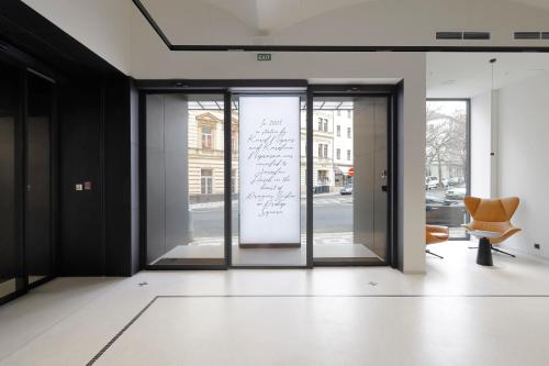 an open door to a building with a sign on the window at Hotel Prokop Square in Prague