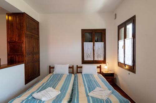 a bedroom with two beds and two windows at Zmas Studios in Chorto