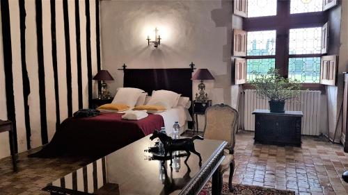 ein Schlafzimmer mit einem Bett und einem Tisch darin in der Unterkunft Manoir de la Beunèche - location du manoir entier in Roézé-sur-Sarthe