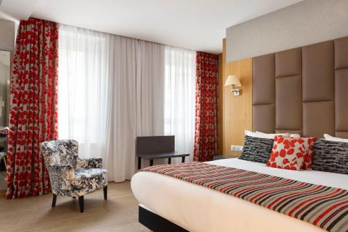 a hotel room with a bed and a chair at Hotel Bristol in Mulhouse