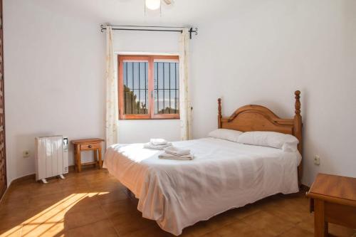 1 dormitorio con cama blanca y ventana en Villa Markus - Plusholidays, en Calpe