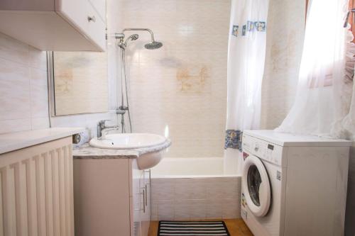 a bathroom with a sink and a washing machine at Villa Markus - Plusholidays in Calpe