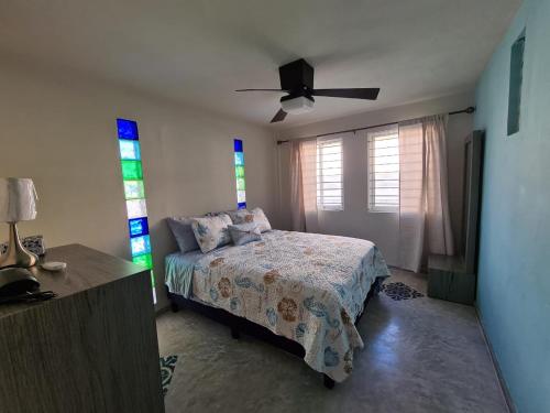 1 dormitorio con 1 cama y ventilador de techo en Palapa rooftop w/ beach views! Cozy Casa Dumas, en Chuburná
