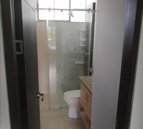 a bathroom with a toilet and a glass shower at Apartamento en Cañaveral in Floridablanca