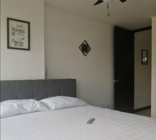 a bedroom with a white bed with a bone on it at Apartamento en Cañaveral in Floridablanca