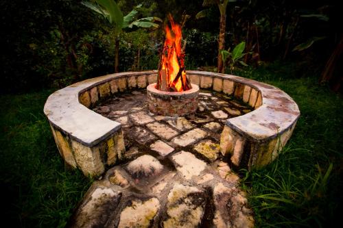 a fire pit with logs and a fire burns at Las Mercedes Finca Cafetera in Cumaca