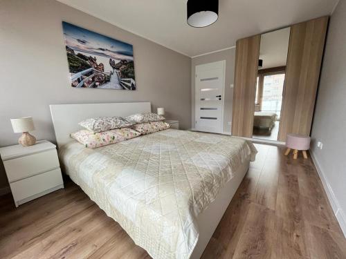 um quarto com uma cama grande e piso em madeira em Apartament Błękitna em Gdynia