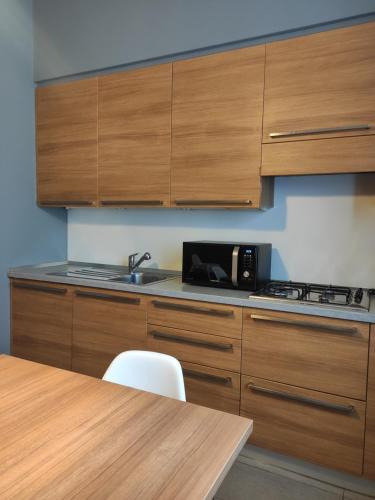 a kitchen with wooden cabinets and a sink and a table at Casa Bianca Apartments in Como