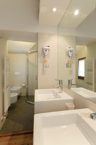 a bathroom with two sinks and a shower and a mirror at Sembenini Palace in Riva del Garda
