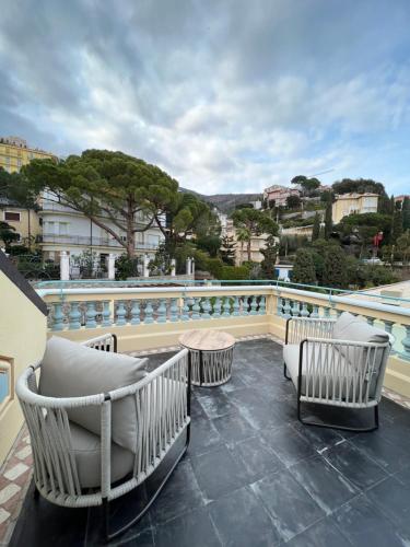 balkon z krzesłami, stołem i basenem w obiekcie Alaxia Luxury Apartments w Alassio