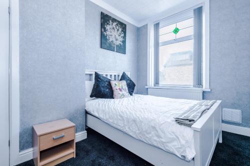 a bedroom with a white bed and a window at Stunning three Bed House in Bradford in Bradford
