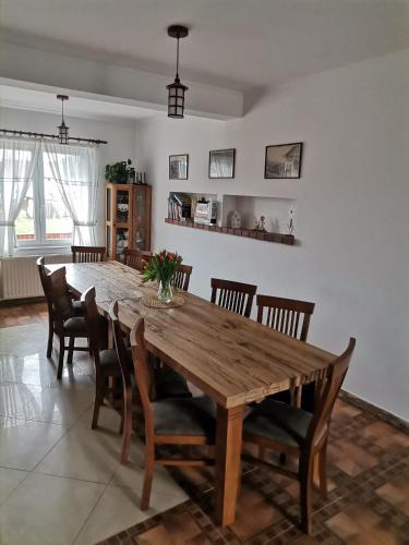 a dining room with a wooden table and chairs at Dió vendégház in Praid