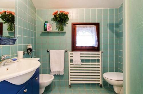 a bathroom with a sink and a toilet and a mirror at Villa Conero in Montacuto