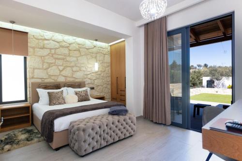 Káïna的住宿－Agapi Luxury Villa，一间卧室设有一张大床和石墙