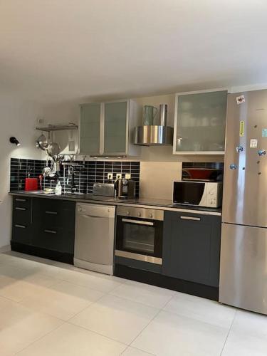 Il comprend une cuisine équipée d'un réfrigérateur et d'appareils en acier inoxydable. dans l'établissement Le Sarana : 75m2, calme, belle vue avec terrasse., à Les Deux Alpes