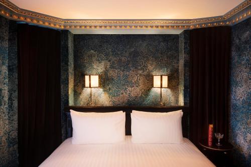 a bedroom with a bed with two white pillows at Maison Proust, Hotel & Spa La Mer in Paris