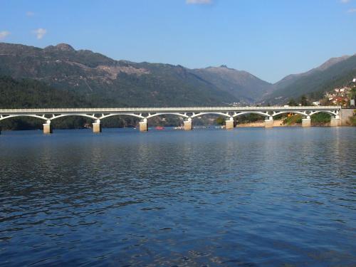 a bridge over a body of water with mountains at Ancoradouro T2 - Alojamento Local Gerês in Braga