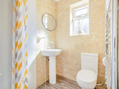 a bathroom with a toilet and a sink at Maceys Cottage - Uk42146 in North Somercotes