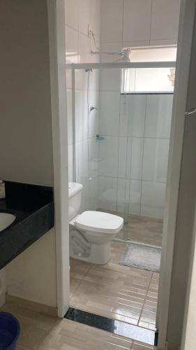 a bathroom with a toilet and a glass shower at Casa Praia&Ferias 300 metros Praia da Enseada in São Francisco do Sul