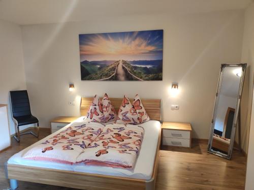 1 dormitorio con 1 cama y una pintura en la pared en Haus Jessica incl Nationalparkcard en Mittersill