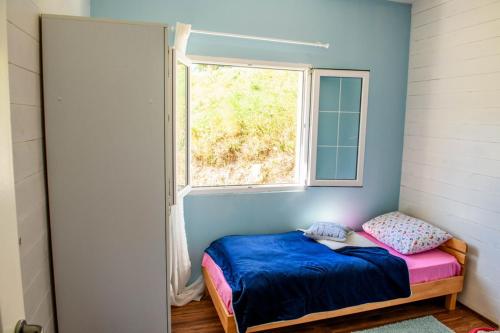 ein kleines Schlafzimmer mit einem Bett und einem Fenster in der Unterkunft Snow White in Kolašin