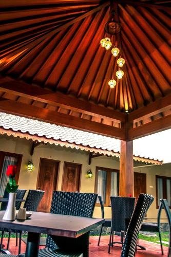 a patio with a table and chairs under a wooden pavilion at Griya Wijilan Syariah in Yogyakarta