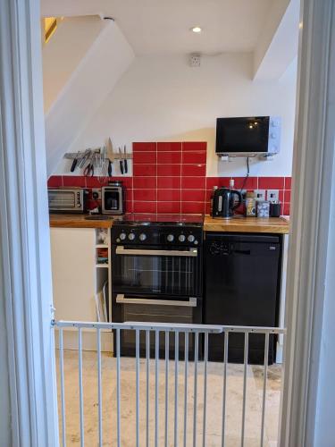 a kitchen with a black stove and a microwave at Spring Gardens, 4-bedroom seaside family home in Shanklin