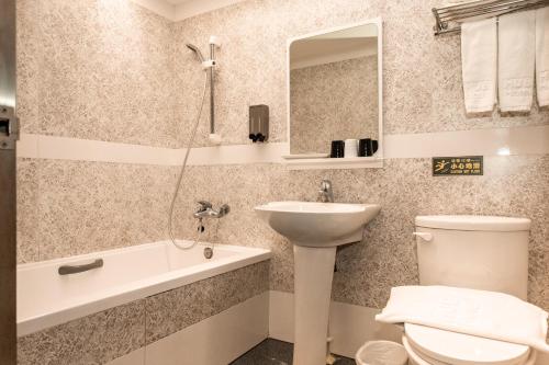 a bathroom with a sink and a toilet and a bath tub at HUB HOTEL Tucheng in Tucheng