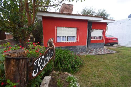 ein rotes Haus mit einem Schild davor in der Unterkunft Kaiken Maison in Villa Santa Cruz del Lago