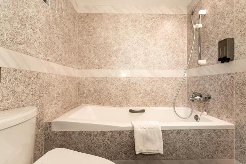 a bathroom with a tub and a toilet at HUB HOTEL Tucheng in Tucheng