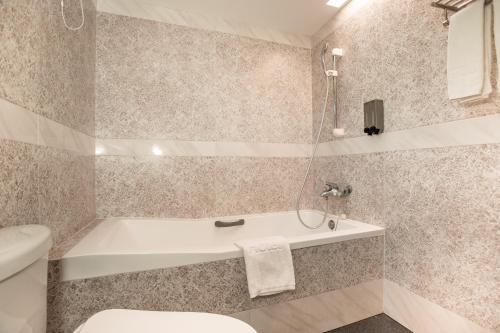 a bathroom with a bath tub and a toilet at HUB HOTEL Tucheng in Tucheng