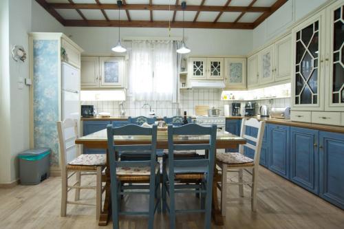 a kitchen with blue cabinets and a table and chairs at Luxury house near by Delphi in Kírra