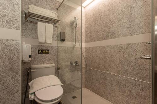 a bathroom with a toilet and a glass shower at HUB HOTEL Tucheng in Tucheng