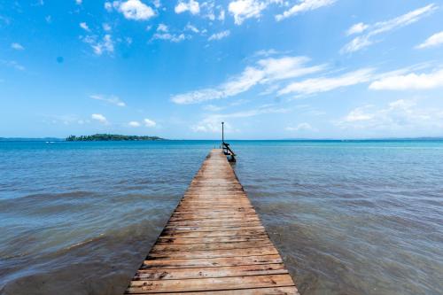a wooden pier in the middle of the water at Casa del Fuego - Caribbean Beachfront Magic! in Bocas Town