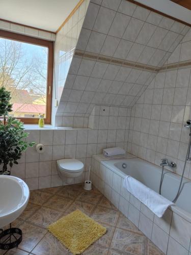 uma casa de banho com uma banheira, um WC e um lavatório. em Ferienwohnung Hohenroda em Hohenroda