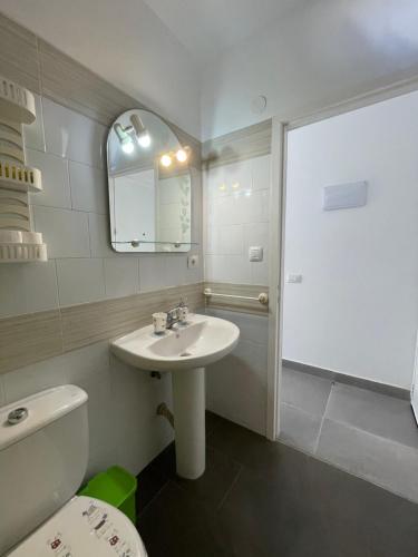 ein Badezimmer mit Waschbecken, Toilette und Spiegel in der Unterkunft Tenerife Primavera in Arona