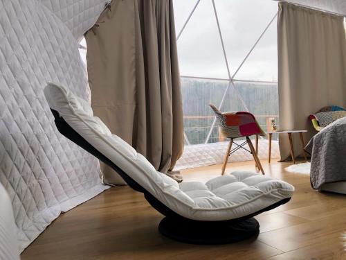 a white bean bag chair in a room with a window at WildGlampingArieseni in Arieşeni