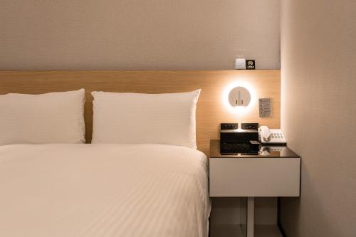a hotel room with a bed and a telephone at HUB HOTEL Tucheng in Tucheng