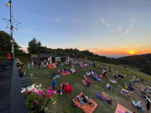 grupa ludzi siedzących w trawie o zachodzie słońca w obiekcie Domek Poniwiec Mała Czantoria w Ustroniu