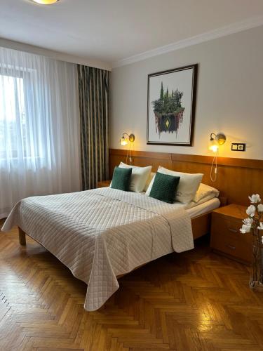 sypialnia z dużym łóżkiem z zielonymi poduszkami w obiekcie WILLA ORNAK w Zakopanem
