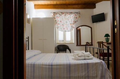 een slaapkamer met een bed, een spiegel en een raam bij B&B Sogni Goti in SantʼAgata deʼ Goti