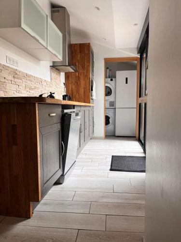 une cuisine avec des armoires en bois et un sol carrelé dans l'établissement Le phare, à Yport