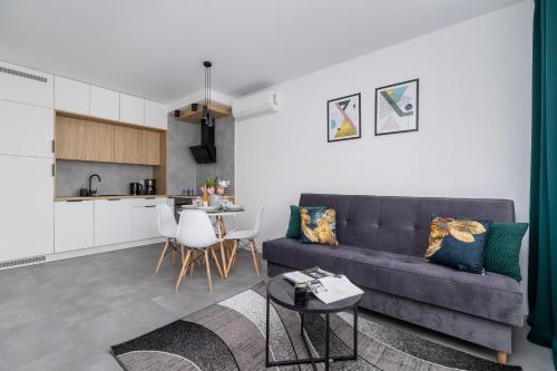 ein Wohnzimmer mit einem Sofa und einem Tisch in der Unterkunft Lux Apartment Grzegórzecka Estate Cracow by Renters Prestige in Krakau