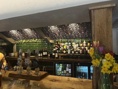 a bar with a bunch of bottles of alcohol at The Talbot Inn in Eynsham