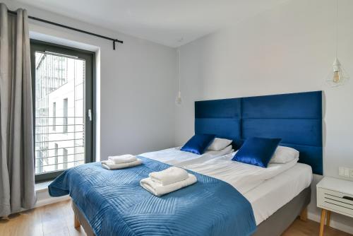 a bedroom with a large bed with blue accents at LTC - Apartments Art Deco Śródmieście in Gdynia
