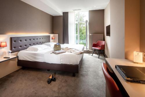 een hotelkamer met een bed en een tafel en stoelen bij Hotel Navarra Brugge in Brugge