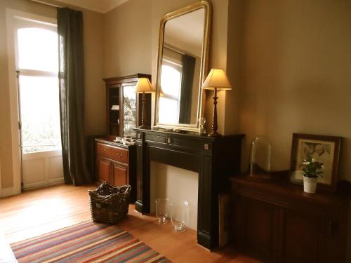 ein Wohnzimmer mit einem großen Spiegel und einer Kommode in der Unterkunft Maison Flagey Brussels in Brüssel
