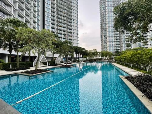 uma grande piscina azul com edifícios altos em Teega Suites by Antlerzone em Nusajaya